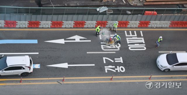 수원특례시 장안구 복합쇼핑몰 스타필드 수원 앞 대로에 ‘광교’ 방면임을 나타내는 도로노면표지가 엉터리 한글로 표기돼 있어 시의 부실한 도로 관리 실태가 도마에 오르고 있다. ‘가’ 사이에 ㅎ자가 ㅗ,ㅏ,ㅇ 자를 대체하며 ‘광’자, ㄱ자와 ㅛ 자가 기괴하게 조합된 ‘교’ 자로 돼있다. 사진은 지난 8일 오후 6시5분께 작업자가 문제의 표기를 지우고 있는 모습. 윤원규기자