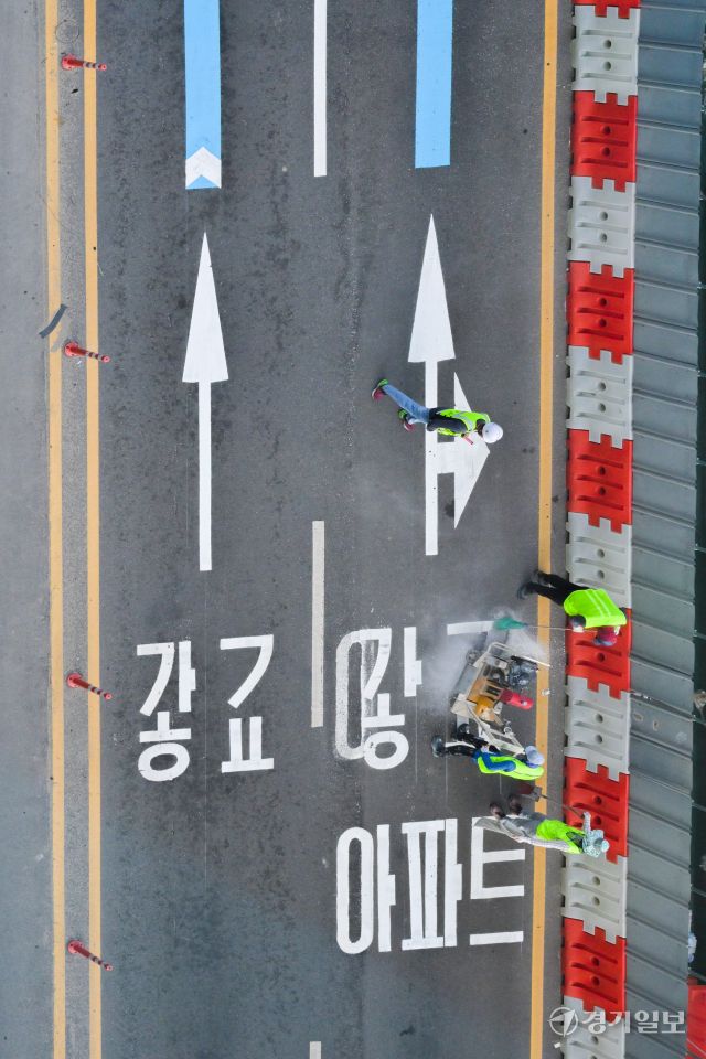 수원특례시 장안구 복합쇼핑몰 스타필드 수원 앞 대로에 ‘광교’ 방면임을 나타내는 도로노면표지가 엉터리 한글로 표기돼 있어 시의 부실한 도로 관리 실태가 도마에 오르고 있다. ‘가’ 사이에 ㅎ자가 ㅗ,ㅏ,ㅇ 자를 대체하며 ‘광’자, ㄱ자와 ㅛ 자가 기괴하게 조합된 ‘교’ 자로 돼있다. 사진은 지난 8일 오후 6시5분께 작업자가 문제의 표기를 지우고 있는 모습. 윤원규기자