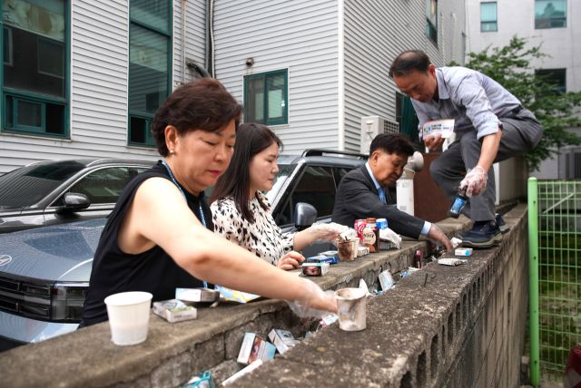 신항철 경기일보 대표이사 회장(오른쪽 두번째)과 (재)지구힐링문화재단 관계자들이 1일 수원시 장안구 송죽동 다세대주택가에서 환경 정화 활동을 진행하고 있다. 민경찬PD