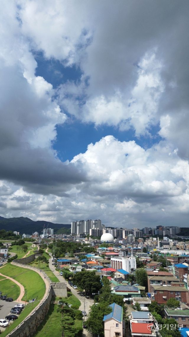 경기지역에 폭염과 소나기가 오락가락 한 1일 오후 세계문화유산 수원화성에서 올려다 본 파란 하늘과 힌구름 먹구름이 어우러져 멋진 모습을 연출하고 있다. 김시범기자
