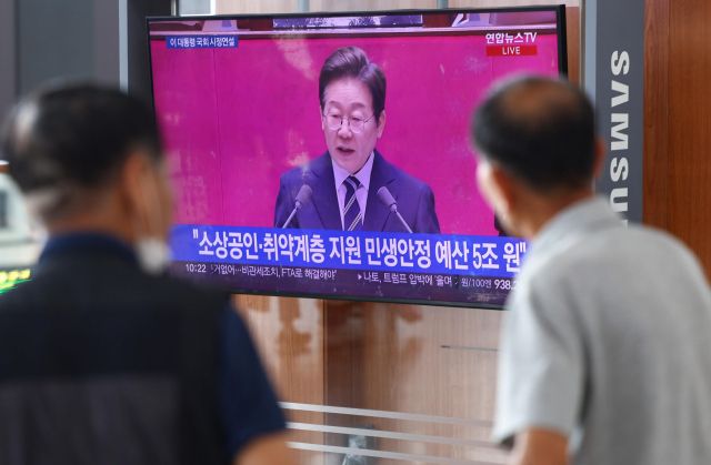 지난달 26일 서울역 대합실에서 시민들이 이재명 대통령의 첫 시정연설 중계방송을 지켜보고 있다. 연합뉴스