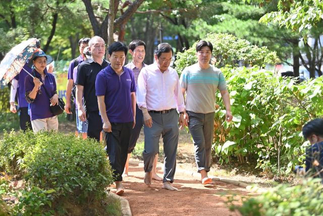 이현재 하남시장과 심재훈 맨길걷기협회 회장 등이 ‘흙향기 맨발길’을 직접 체험하고 있다. 하남시 제공