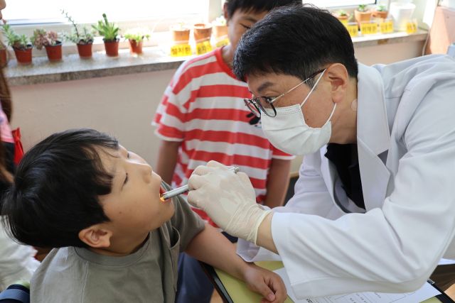 지난 10일 화성 석촌초등학교에서 경기도치과의사회 회원이 학생의 구강검진을 하고 있다. 경기도치과의사회 제공