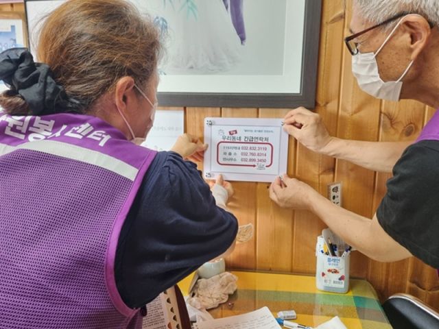 옹진군 자원봉사센터 관계자들이 연평면과 대청면에서 긴급연락처를 적은 아크릴 안내판을 설치하고 있다. 군 제공