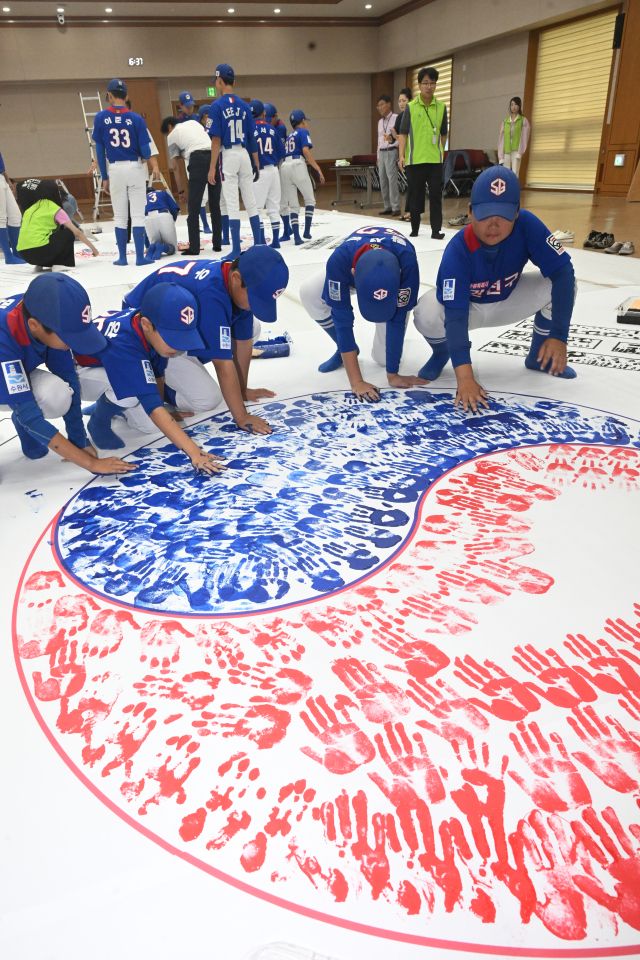 제80주년 광복절을 한 달 앞둔 15일 오후 수원특례시 권선구청에서 권선구 리틀야구단, 보훈단체 관계자, 공직자 등이 손도장 태극기를 만들고 있다.조주현기자