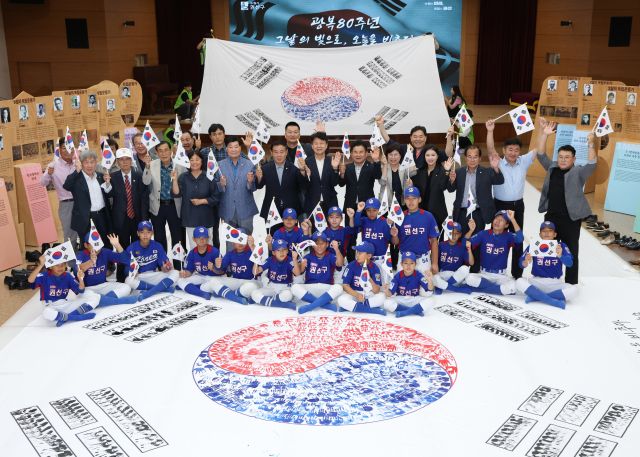제80주년 광복절을 한 달 앞둔 15일 오후 수원특례시 권선구청에서 권선구 리틀야구단, 보훈단체 관계자, 공직자 등이 손도장 태극기를 만든 뒤 기념 촬영을 하고 있다.조주현기자
