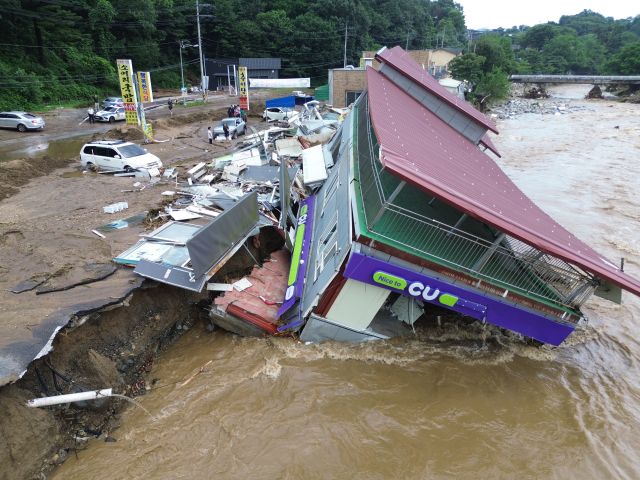 20일 가평군 조종면 신상리 십이탄천 인근에서 폭우로 붕괴된 편의점 건물이 물에 잠겨 있다. 집중호우로 인근 주택 3채도 산사태에 파손됐으며, 주민들은 단전과 단수 피해를 겪고 있다.조주현기자
