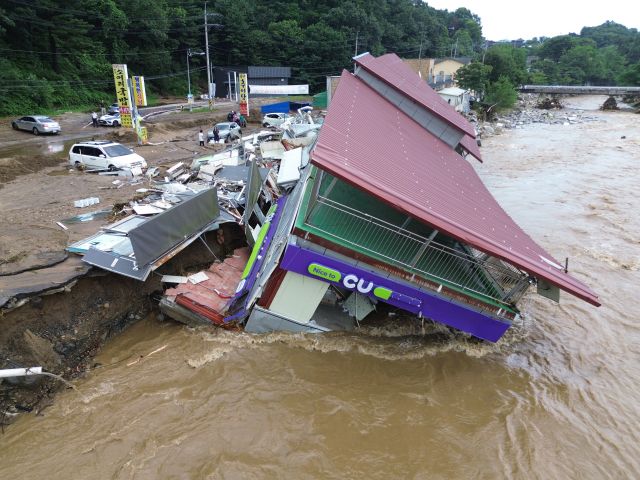 20일 가평군 조종면 신상리 십이탄천 인근에서 폭우로 붕괴된 편의점 건물이 물에 잠겨 있다. 집중호우로 인근 주택 3채도 산사태에 파손됐으며, 주민들은 단전과 단수 피해를 겪고 있다.조주현기자