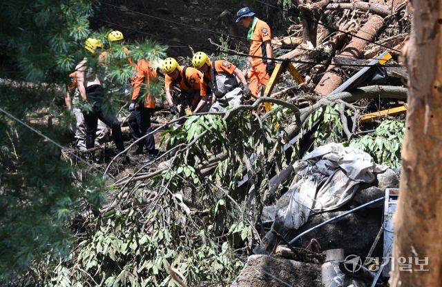 21일 오후 가평군 조종면 마일리의 한 캠핑장에서 구조대원들이 토사와 쓰러진 나무를 하나하나 치우며 산사태로 실종된 어머니와 중학생 아들을 찾고 있다. 전날 새벽 쏟아진 폭우로 토사가 글램핑장을 덮치면서 일가족 4명이 매몰됐고, 이 가운데 10대 아들은 부상을 입고 구조됐으나 40대 아버지는 조종천 하류에서 숨진 채 발견됐다. 중장비 진입이 어려운 현장에서 구조대는 이틀째 수색을 이어가고 있다.조주현기자