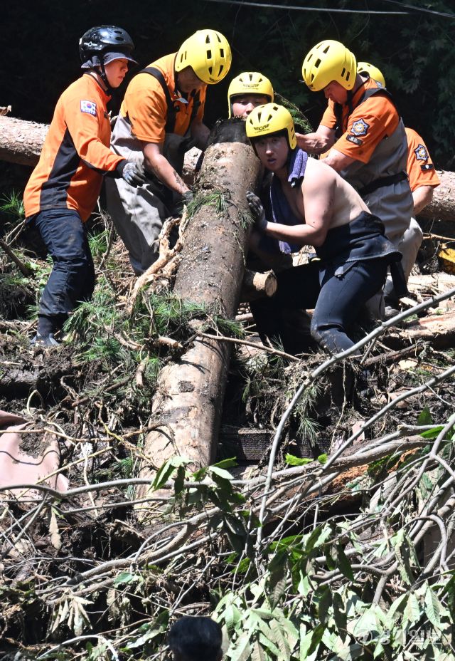 21일 오후 가평군 조종면 마일리의 한 캠핑장에서 구조대원들이 토사와 쓰러진 나무를 하나하나 치우며 산사태로 실종된 어머니와 중학생 아들을 찾고 있다. 전날 새벽 쏟아진 폭우로 토사가 글램핑장을 덮치면서 일가족 4명이 매몰됐고, 이 가운데 10대 아들은 부상을 입고 구조됐으나 40대 아버지는 조종천 하류에서 숨진 채 발견됐다. 중장비 진입이 어려운 현장에서 구조대는 이틀째 수색을 이어가고 있다.조주현기자