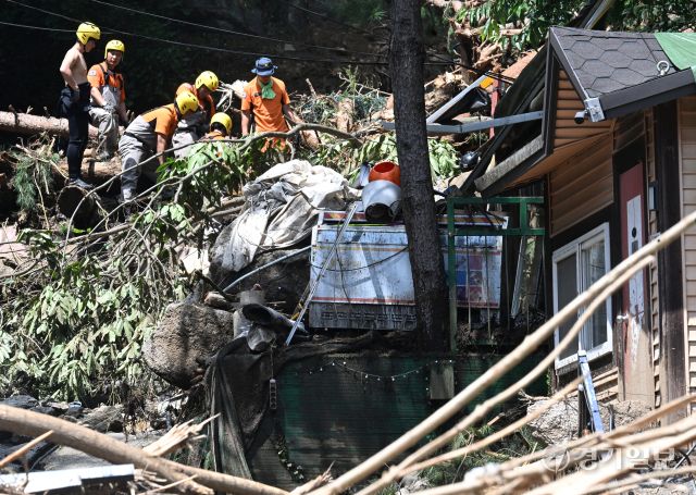 21일 오후 가평군 조종면 마일리의 한 캠핑장에서 구조대원들이 토사와 쓰러진 나무를 하나하나 치우며 산사태로 실종된 어머니와 중학생 아들을 찾고 있다. 전날 새벽 쏟아진 폭우로 토사가 글램핑장을 덮치면서 일가족 4명이 매몰됐고, 이 가운데 10대 아들은 부상을 입고 구조됐으나 40대 아버지는 조종천 하류에서 숨진 채 발견됐다. 중장비 진입이 어려운 현장에서 구조대는 이틀째 수색을 이어가고 있다.조주현기자
