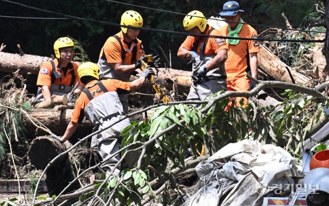 21일 오후 가평군 조종면 마일리의 한 캠핑장에서 구조대원들이 토사와 쓰러진 나무를 하나하나 치우며 산사태로 실종된 어머니와 중학생 아들을 찾고 있다. 전날 새벽 쏟아진 폭우로 토사가 글램핑장을 덮치면서 일가족 4명이 매몰됐고, 이 가운데 10대 아들은 부상을 입고 구조됐으나 40대 아버지는 조종천 하류에서 숨진 채 발견됐다. 중장비 진입이 어려운 현장에서 구조대는 이틀째 수색을 이어가고 있다.조주현기자