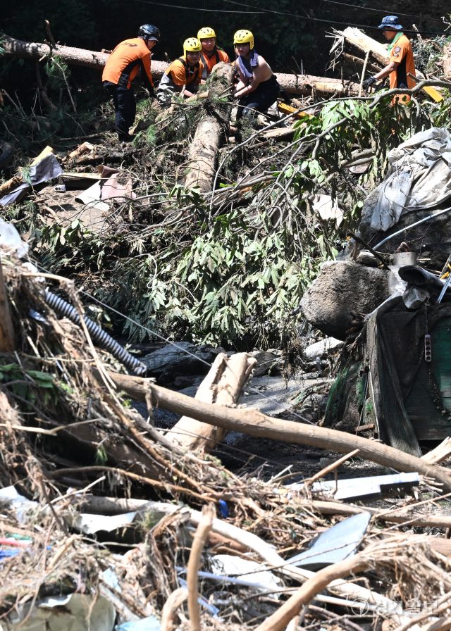 21일 오후 가평군 조종면 마일리의 한 캠핑장에서 구조대원들이 토사와 쓰러진 나무를 하나하나 치우며 산사태로 실종된 어머니와 중학생 아들을 찾고 있다. 전날 새벽 쏟아진 폭우로 토사가 글램핑장을 덮치면서 일가족 4명이 매몰됐고, 이 가운데 10대 아들은 부상을 입고 구조됐으나 40대 아버지는 조종천 하류에서 숨진 채 발견됐다. 중장비 진입이 어려운 현장에서 구조대는 이틀째 수색을 이어가고 있다.조주현기자