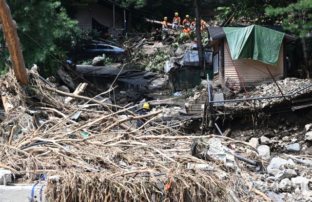 21일 오후 가평군 조종면 마일리의 한 캠핑장에서 구조대원들이 토사와 쓰러진 나무를 하나하나 치우며 산사태로 실종된 어머니와 중학생 아들을 찾고 있다. 전날 새벽 쏟아진 폭우로 토사가 글램핑장을 덮치면서 일가족 4명이 매몰됐고, 이 가운데 10대 아들은 부상을 입고 구조됐으나 40대 아버지는 조종천 하류에서 숨진 채 발견됐다. 중장비 진입이 어려운 현장에서 구조대는 이틀째 수색을 이어가고 있다.조주현기자