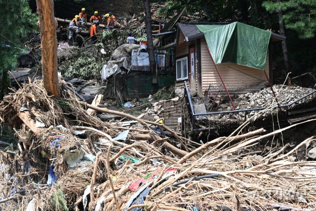 21일 오후 가평군 조종면 마일리의 한 캠핑장에서 구조대원들이 토사와 쓰러진 나무를 하나하나 치우며 산사태로 실종된 어머니와 중학생 아들을 찾고 있다. 전날 새벽 쏟아진 폭우로 토사가 글램핑장을 덮치면서 일가족 4명이 매몰됐고, 이 가운데 10대 아들은 부상을 입고 구조됐으나 40대 아버지는 조종천 하류에서 숨진 채 발견됐다. 중장비 진입이 어려운 현장에서 구조대는 이틀째 수색을 이어가고 있다.조주현기자