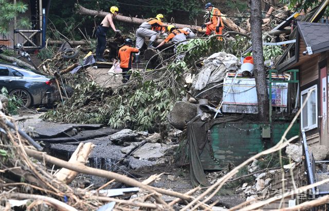 21일 오후 가평군 조종면 마일리의 한 캠핑장에서 구조대원들이 토사와 쓰러진 나무를 하나하나 치우며 산사태로 실종된 어머니와 중학생 아들을 찾고 있다. 전날 새벽 쏟아진 폭우로 토사가 글램핑장을 덮치면서 일가족 4명이 매몰됐고, 이 가운데 10대 아들은 부상을 입고 구조됐으나 40대 아버지는 조종천 하류에서 숨진 채 발견됐다. 중장비 진입이 어려운 현장에서 구조대는 이틀째 수색을 이어가고 있다.조주현기자