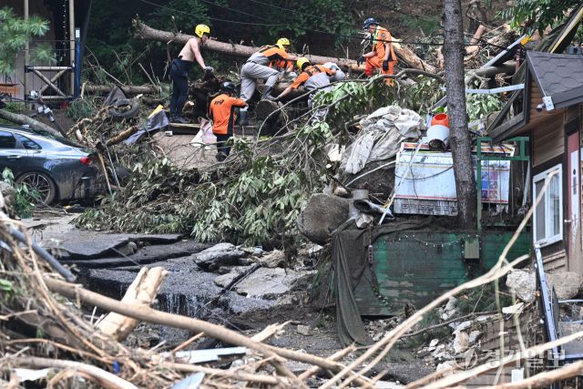 21일 오후 가평군 조종면 마일리의 한 캠핑장에서 구조대원들이 토사와 쓰러진 나무를 하나하나 치우며 산사태로 실종된 어머니와 중학생 아들을 찾고 있다. 전날 새벽 쏟아진 폭우로 토사가 글램핑장을 덮치면서 일가족 4명이 매몰됐고, 이 가운데 10대 아들은 부상을 입고 구조됐으나 40대 아버지는 조종천 하류에서 숨진 채 발견됐다. 중장비 진입이 어려운 현장에서 구조대는 이틀째 수색을 이어가고 있다.조주현기자