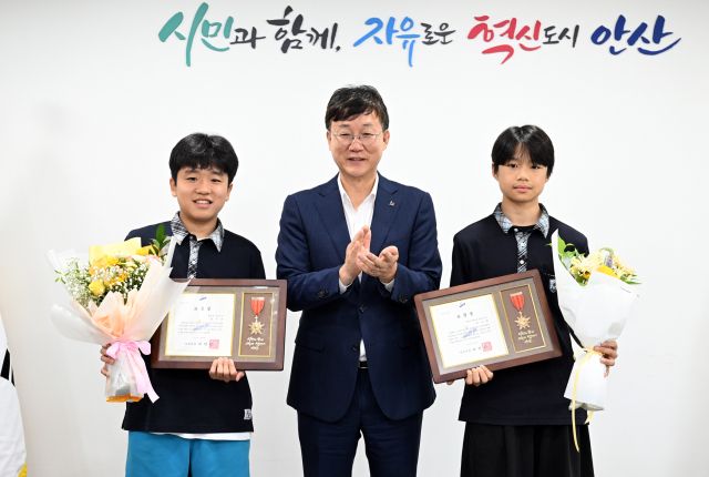 무더위 속 폐지를 싫은 무거운 수레를 끌고 거리를 지나던 어르신을 도운 중학교 재학생 2명 안산시장으로 선행 표창장을 받았다(사진의 왼쪽이 양시온·오른쪽은 유호현 학생). 안산시 제공