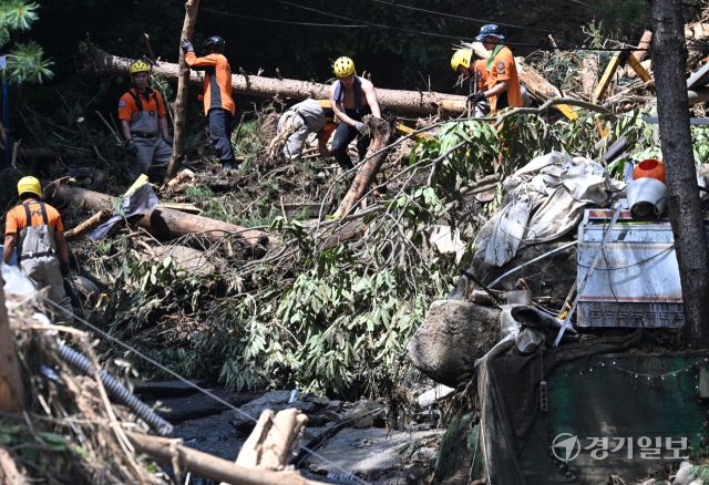 21일 오후 가평군 조종면 마일리의 한 캠핑장에서 구조대원들이 토사와 쓰러진 나무를 하나하나 치우며 산사태로 실종된 어머니와 중학생 아들을 찾고 있다. 전날 새벽 쏟아진 폭우로 토사가 글램핑장을 덮치면서 일가족 4명이 매몰됐고, 이 가운데 10대 아들은 부상을 입고 구조됐으나 40대 아버지는 조종천 하류에서 숨진 채 발견됐다. 중장비 진입이 어려운 현장에서 구조대는 이틀째 수색을 이어가고 있다.조주현기자