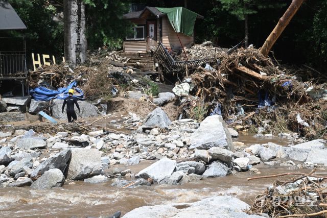 21일 오후 가평군 조종면 마일리의 한 캠핑장에서 구조대원들이 토사와 쓰러진 나무를 하나하나 치우며 산사태로 실종된 어머니와 중학생 아들을 찾고 있다. 전날 새벽 쏟아진 폭우로 토사가 글램핑장을 덮치면서 일가족 4명이 매몰됐고, 이 가운데 10대 아들은 부상을 입고 구조됐으나 40대 아버지는 조종천 하류에서 숨진 채 발견됐다. 중장비 진입이 어려운 현장에서 구조대는 이틀째 수색을 이어가고 있다.조주현기자