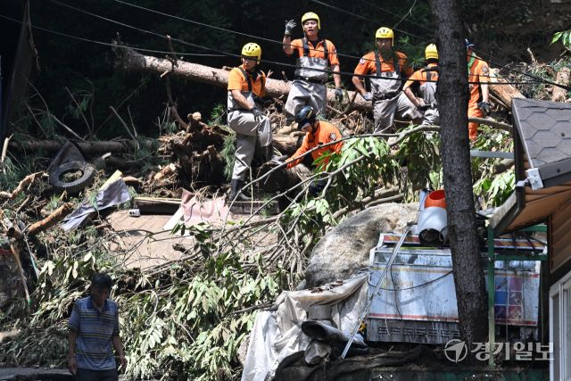 21일 오후 가평군 조종면 마일리의 한 캠핑장에서 구조대원들이 토사와 쓰러진 나무를 하나하나 치우며 산사태로 실종된 어머니와 중학생 아들을 찾고 있다. 전날 새벽 쏟아진 폭우로 토사가 글램핑장을 덮치면서 일가족 4명이 매몰됐고, 이 가운데 10대 아들은 부상을 입고 구조됐으나 40대 아버지는 조종천 하류에서 숨진 채 발견됐다. 중장비 진입이 어려운 현장에서 구조대는 이틀째 수색을 이어가고 있다.조주현기자