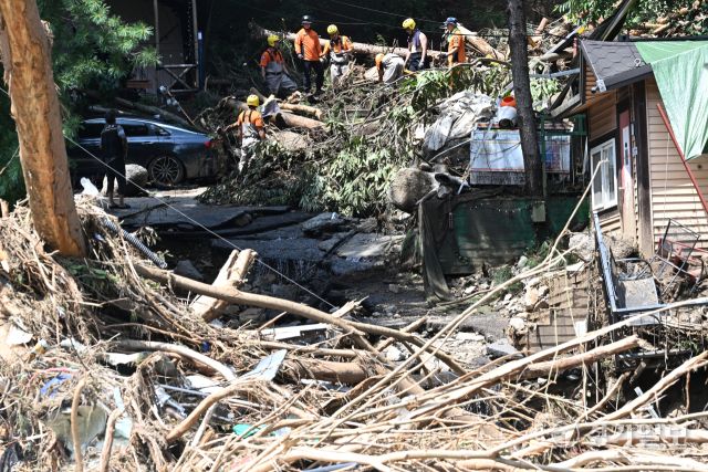 21일 오후 가평군 조종면 마일리의 한 캠핑장에서 구조대원들이 토사와 쓰러진 나무를 하나하나 치우며 산사태로 실종된 어머니와 중학생 아들을 찾고 있다. 전날 새벽 쏟아진 폭우로 토사가 글램핑장을 덮치면서 일가족 4명이 매몰됐고, 이 가운데 10대 아들은 부상을 입고 구조됐으나 40대 아버지는 조종천 하류에서 숨진 채 발견됐다. 중장비 진입이 어려운 현장에서 구조대는 이틀째 수색을 이어가고 있다.조주현기자