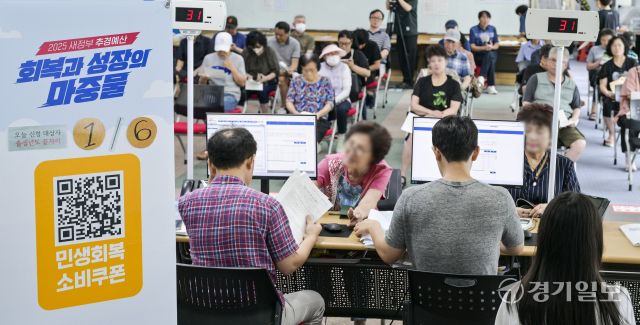 이재명 정부의 첫 대규모 경기 부양책인 '민생회복 소비쿠폰' 신청이 시작된 21일 오전 수원특례시 인계동 행정복지센터에서 시민들이 소비쿠폰을 신청하고 있다. 신청 첫 주인 21∼25일에는 시스템 과부하와 주민센터 혼잡 방지를 위해 출생 연도 끝자리 기준 요일제를 운영한다. 끝자리 1·6은 월요일, 2·7은 화요일, 3·8은 수요일, 4·9는 목요일, 5·0은 금요일에 신청할 수 있다. 주말에는 온라인 신청만 할 수 있다.