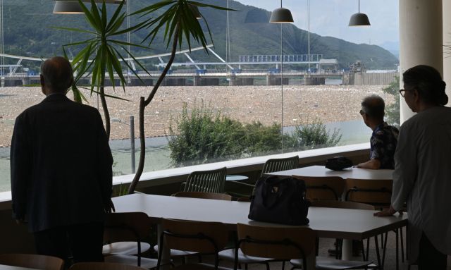 23일 하남시 팔당댐 인근 카페에서 손님들이 팔당댐에 쌓인 쓰레기더미를 바라보고 있다. 조주현기자