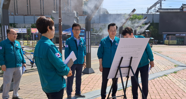 하병필 인천시 행정부시장이 인천 동구 동인천역에 설치한 쿨링포그를 직접 체험하고 폭염 종합대책에 대한 설명을 듣고 있다. 인천시 제공