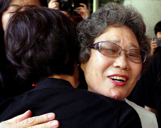 최말자(78)씨가 23일 부산지법에서 열린 재심 첫 공판을 마치고 법정을 나서며 변호인과 여성단체와 포옹하고 있다. 연합뉴스