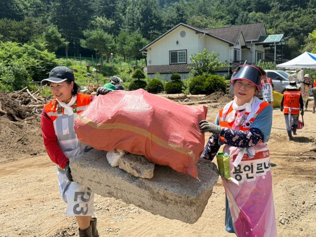 25일 집중호우로 큰 피해를 입은 가평군 일대에서 용인시자원봉사센터 ‘레디-용(Read-Yong)’ 봉사단이 복구 작업을 펼치고 있다. 용인시자원봉사센터 제공