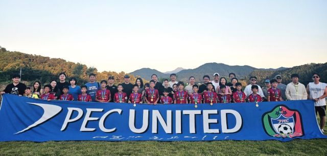 ‘2025 자연울림 괴산유소년축구페스티벌’에서 U-11 우승을 차지한 PEC 유나이티드 선수단이 학부모들과 기념촬영을 하고 있다.PEC 유나이티드 제공