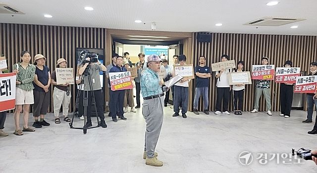 지난 10일 시흥~수원 고속화도로 민간투자사업 주민설명회가 열린 군포시청 대회의실 앞에서 김정태 주민대표가 사업 반대 발언을 하고 있다. 윤덕흥기자