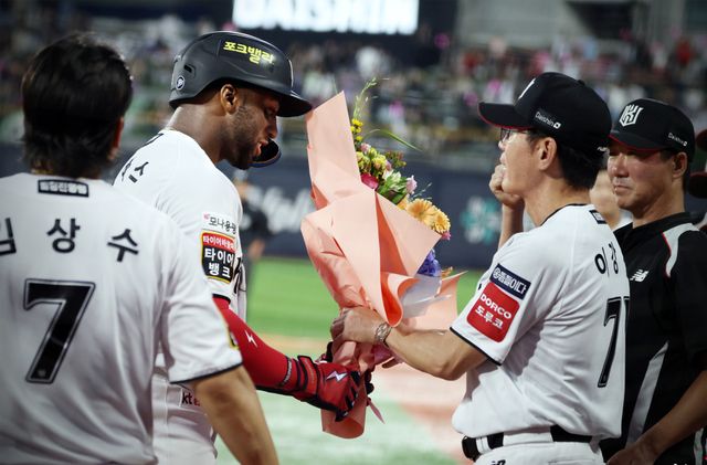 3일 키움전서 KBO리그 통산 외국인 타자 최다 홈런을 기록한 멜 로하스 주니어(왼쪽)에게 이강철 감독이 꽃다발을 건네며 축하해주고 있다.KT 위즈 제공