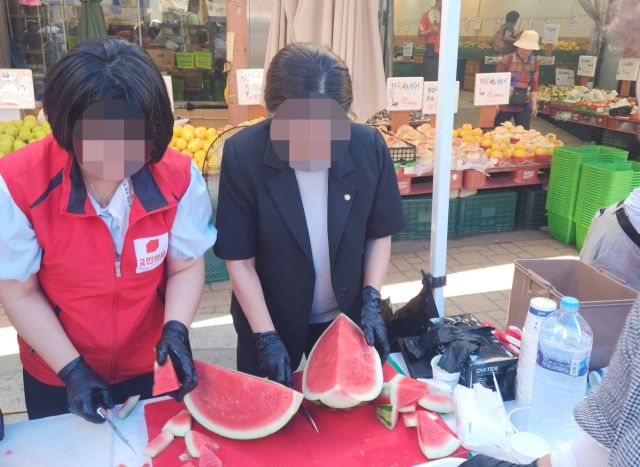 국민의힘 인천시당 남동구갑 당원협의회의 한 관계자가 국민의힘이 적힌 조끼를 입고 수박 나눔 행사에 참여하고 있다. 독자 제공