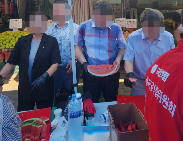 국민의힘 인천시당 남동구갑 당원협의회의 한 관계자가 국민의힘이 적힌 조끼를 입고 수박 나눔 행사에 참여하고 있다. 독자 제공