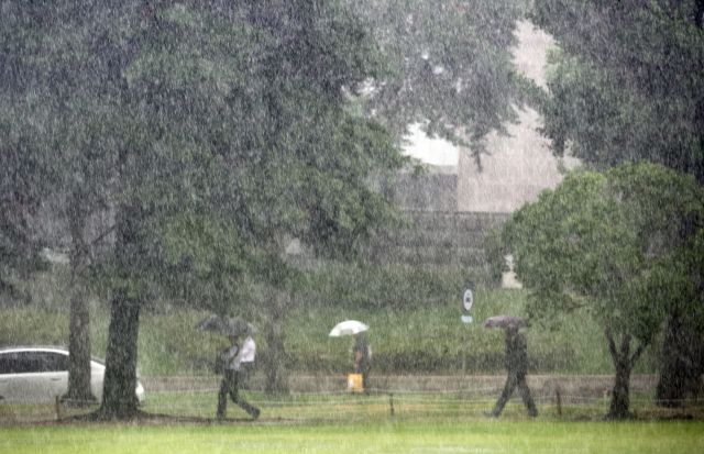 8일 서울 영등포구 여의도 국회에서 시민들이 우산을 쓰고 지나가는 모습. 연합뉴스