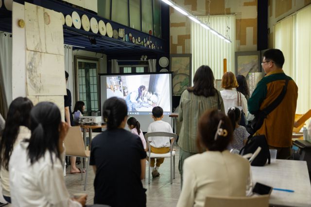 ‘2025 옆집에 사는 예술가 × 용인’ 오픈스튜디오 프로그램에 참여한 시민들이 작가의 작업실을 둘러보며 설명을 듣고 있다. 용인문화재단 제공