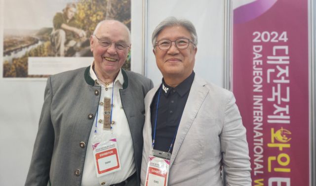 도서 ‘DMZ 평화와인’의 저자 김덕배씨가 2024 대전국제 와인 EXPO에서 모젤와인협회 아돌프 슈미트 회장(왼쪽)과 사진을 촬영하고 있다. 본인 제공