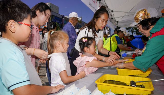 10일 오전 광복 80주년을 맞아 상록수역 손바닥 페인팅 행사에서 시민들과 아이들이 태극기에 손도장을 찍을 준비를 하고 있다.