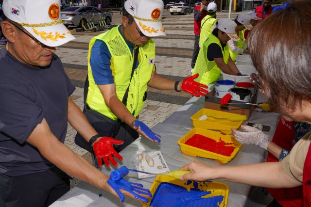 10일 오전 광복 80주년을 맞아 상록수역 손바닥 페인팅 행사에서 광복회 회원들이 태극기에 손도장을 찍을 준비를 하고 있다.