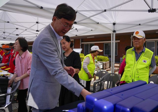 10일 오전 광복 80주년을 맞아 상록수역 태극기 나눔 부스에서 이민근 안산 시장이 태극기를 확인하고 있다.