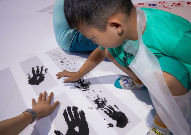 10일 오전 광복 80주년을 맞아 상록수역 손바닥 페인팅 행사에서 아이가 태극기에 손도장을 찍고 있다.