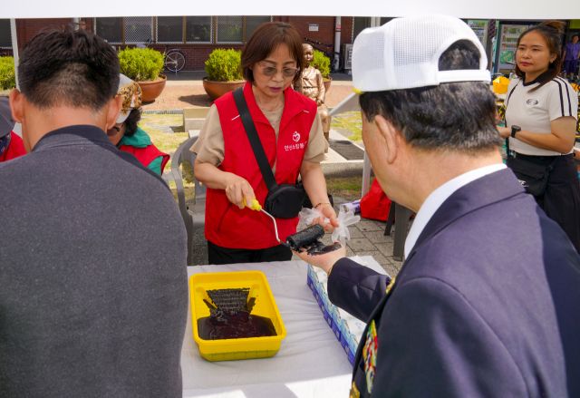 10일 오전 광복 80주년을 맞아 상록수역 손바닥 페인팅 행사에서 시민과 광복회 회원이 태극기에 손도장을 찍을 준비를 하고 있다.