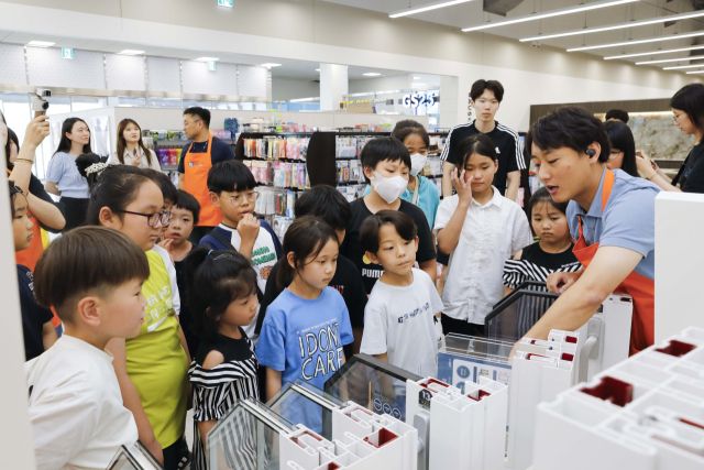 홈씨씨 수원점에서 진행된 멘토링 교육 프로그램에 참여한 어린이들이 창호 제품에 대한 설명을 듣고 있다. KCC글라스 제공