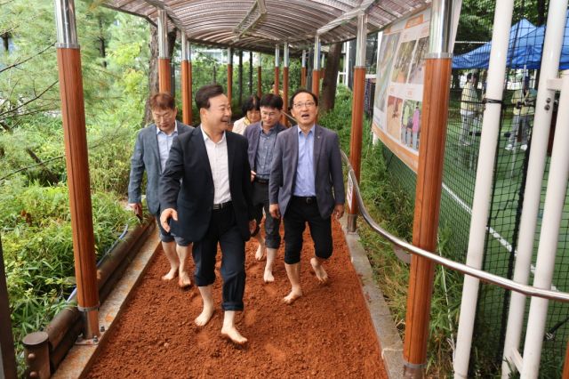 김성제 의왕시장과 관계자들이 오전로 가족공원황톳길을 걷고 있다. 의왕시 제공