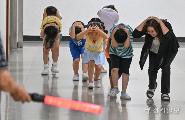2025 을지연습과 연계한 공습 대비 민방위훈련이 실시된 20일 오후 수원 효동초에서 공습경보 사이렌 속에 학생들이 머리를 감싼 채 대피장소로 이동하는 등 실전 같은 훈련을 하고 있다. 김시범기자