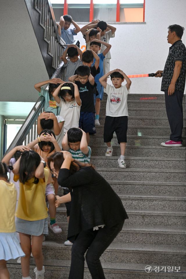 2025 을지연습과 연계한 공습 대비 민방위훈련이 실시된 20일 오후 수원 효동초에서 공습경보 사이렌 속에 학생들이 머리를 감싼 채 대피장소로 이동하는 등 실전 같은 훈련을 하고 있다. 김시범기자