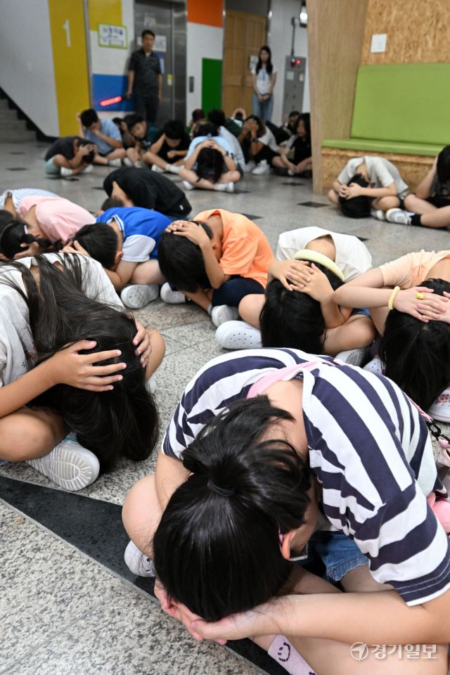 2025 을지연습과 연계한 공습 대비 민방위훈련이 실시된 20일 오후 수원 효동초에서 공습경보 사이렌 속에 학생들이 머리를 감싼 채 대피장소로 이동하는 등 실전 같은 훈련을 하고 있다. 김시범기자