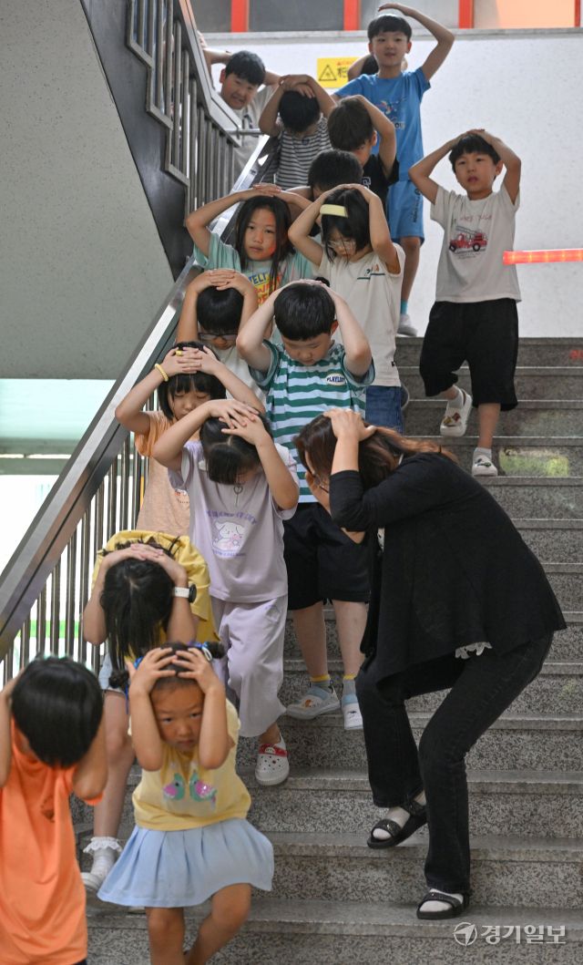 2025 을지연습과 연계한 공습 대비 민방위훈련이 실시된 20일 오후 수원 효동초에서 공습경보 사이렌 속에 학생들이 머리를 감싼 채 대피장소로 이동하는 등 실전 같은 훈련을 하고 있다. 김시범기자